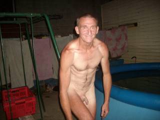 husband getting ready for skinny dipping in pool