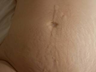 Patty's tummy after I shot my load on it. Her belly button is the sexy deep, dark, round type, but I directed my squirts to fill it up in this photo.
