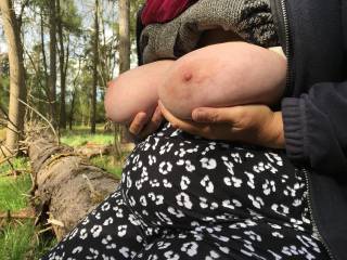 On a fallen tree in woodland sits my friend, holding her big tits ;)