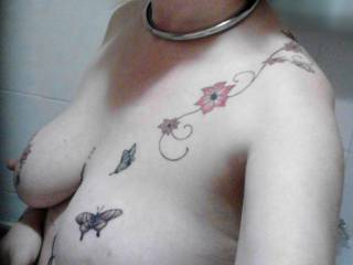 A topless photo  of Sally offering a nice view of her tits, tattoos and collar.