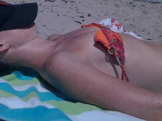 Her tits are tiny, perky and perfect on the beach.
