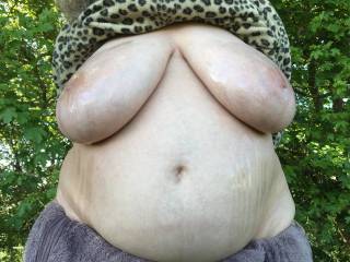 Baby oil everywhere - my lovely friend put a load over her big tits. Some drops still below them, and some of it ran off them in streaks on to her belly as well. A nice shiny outdoor scene