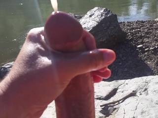 hubby stroking his cock outside on a nude beach at the river and caught the cumshot just perfectly.