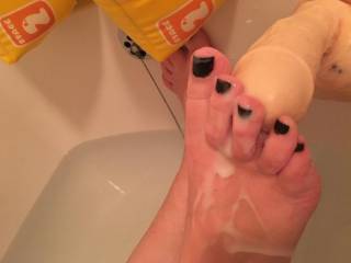 She had just finished painting her toes black and got into the bath with her cum squirting dildo. She likes cum on her feet, the following night we met a black guy (hence black nail polish) and he sucked her toes! She tugged his dick fucking hot!!!!