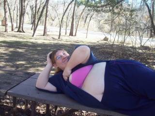 Wife laying on a park bench flashing her pink bra