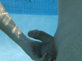 Playing with his soft cock and balls underwater, in our swimming pool at home.
