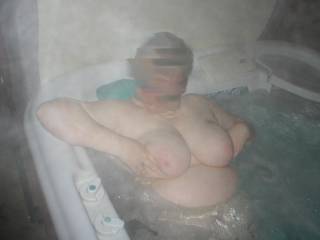 Wife playing with her big tits in the hot tub